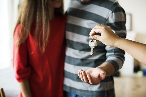 A couple getting keys handed to them for their new home