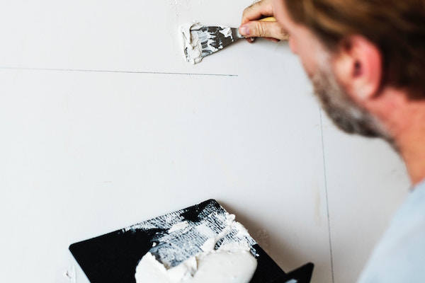 A painter painting walls white